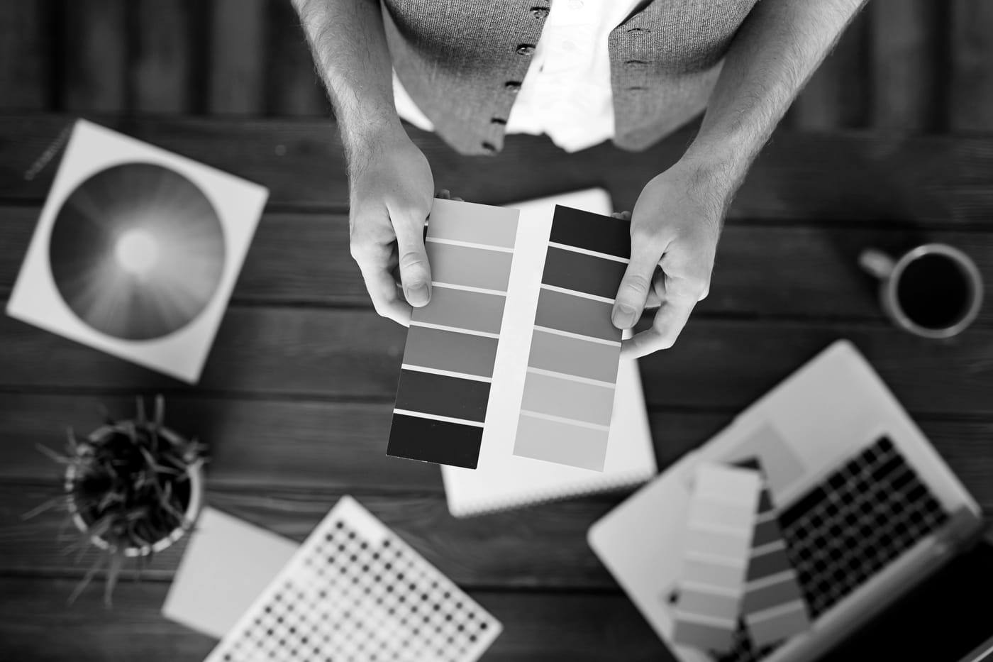 Renk kartelaları arasından seçim yapan tasarımcı elleri
